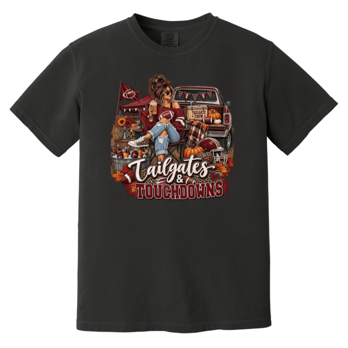 Black graphic T-shirt with a detailed autumn football scene printed on the front, including a truck, pumpkins, sunflowers, and the text 'Tailgates & Touchdowns'.