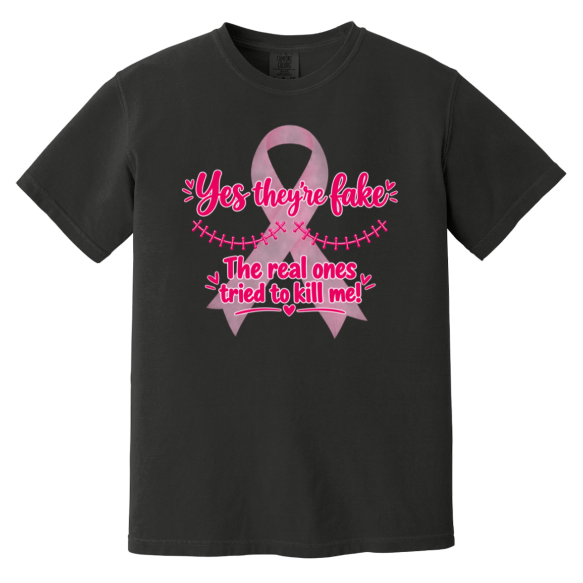 A black short-sleeve t-shirt with a pink graphic on the front. The graphic features a pink ribbon and the text 'Yes they're fake' and 'The real ones tried to kill me!' in pink lettering.