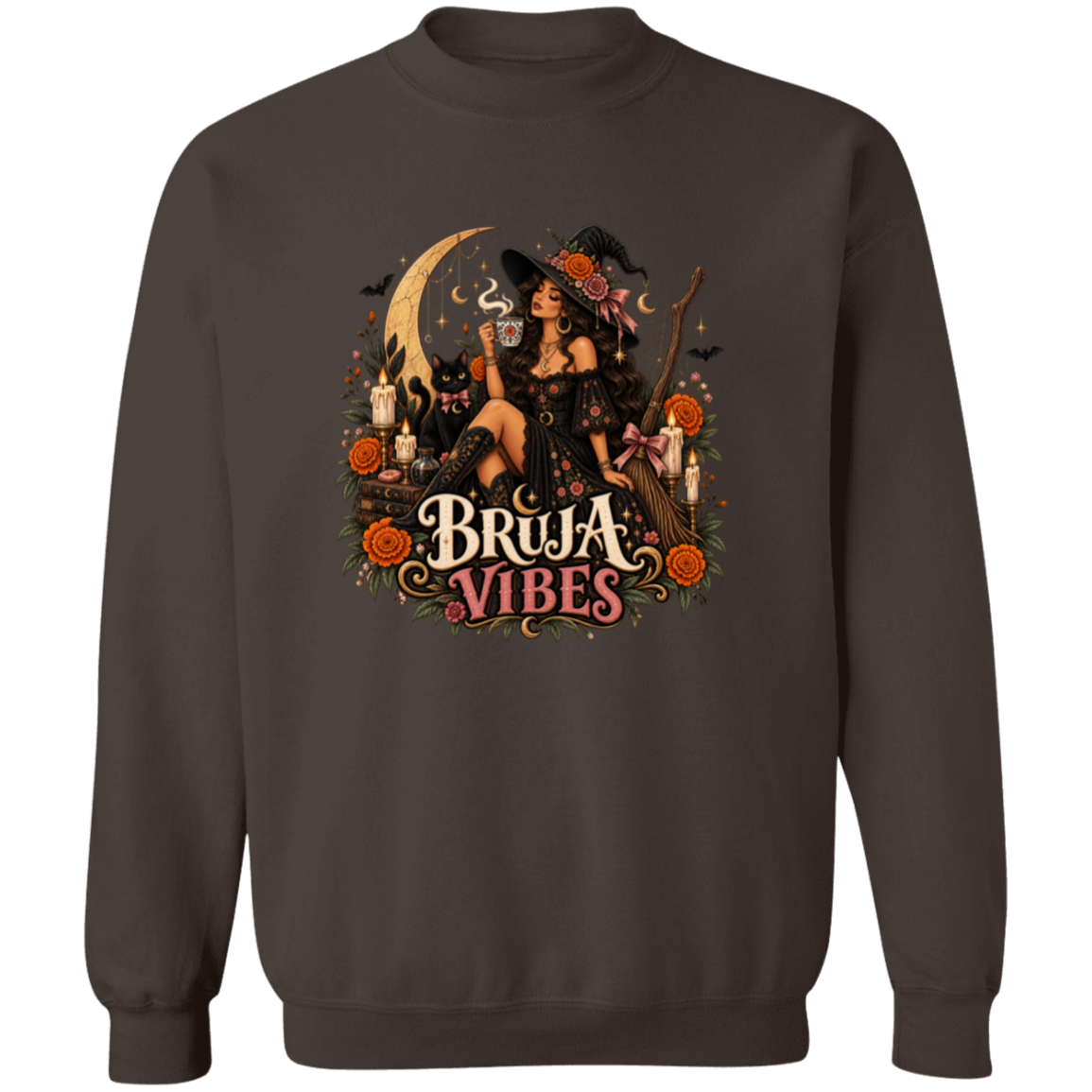 A brown crewneck sweatshirt with a large graphic print on the front. The graphic features a witch in a black hat sitting on a broomstick next to a black cat, surrounded by orange flowers and the text 'BRUJA VIBES'.