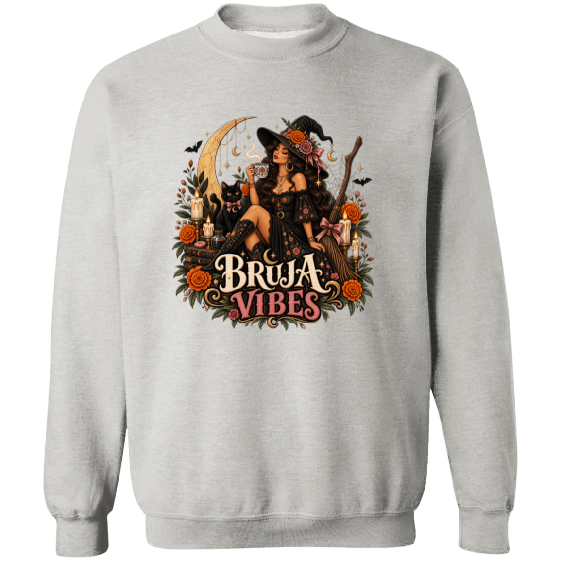 Light gray crewneck sweatshirt with a large graphic print on the front. The graphic features a witch in a black hat sitting on a broomstick next to a black cat, surrounded by orange flowers and the text 'BRUJA VIBES'.