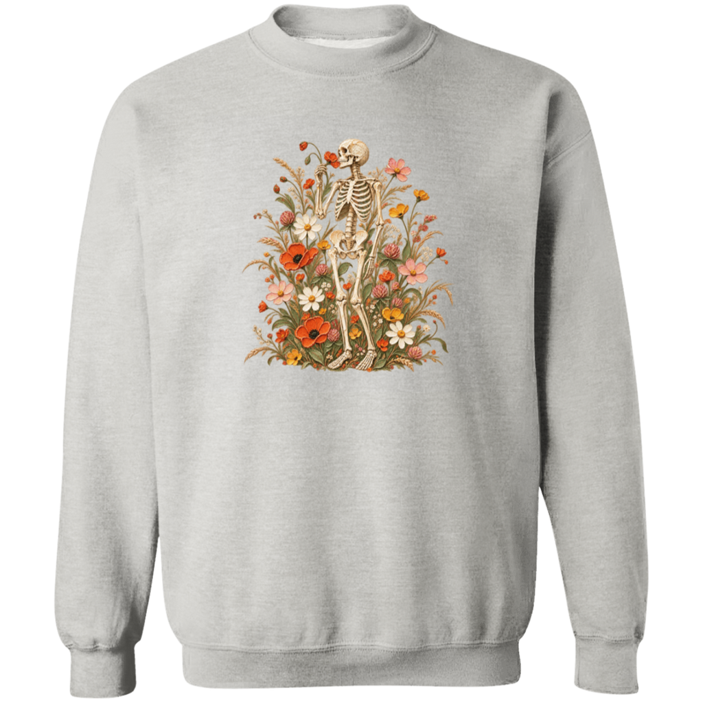 A light gray crewneck sweatshirt featuring a vintage-style graphic of a skeleton surrounded by a dense arrangement of red, orange, yellow, and white wildflowers.