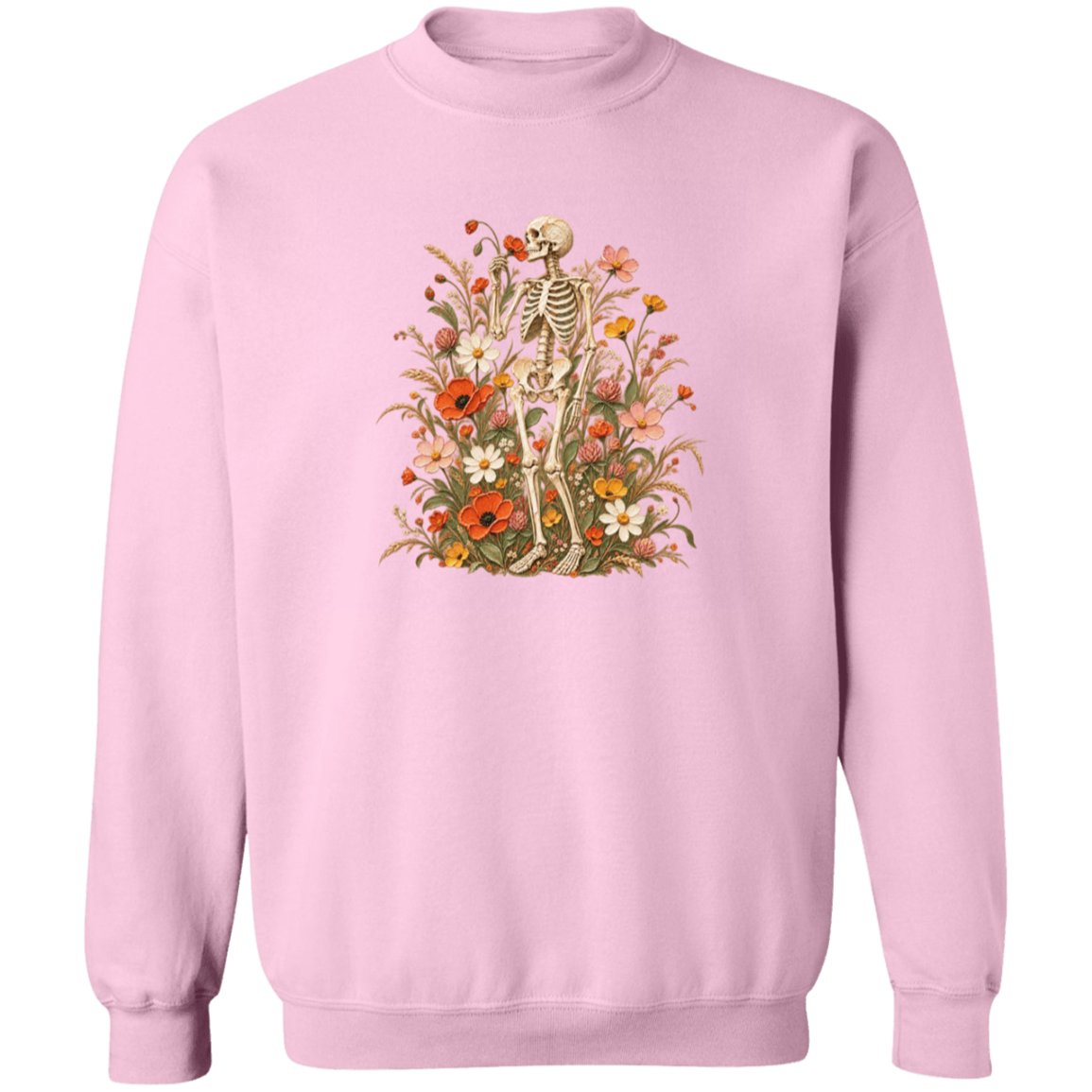 A light pink crewneck sweatshirt featuring a vintage-style graphic of a skeleton standing amidst a dense arrangement of red, orange, yellow, and white wildflowers.
