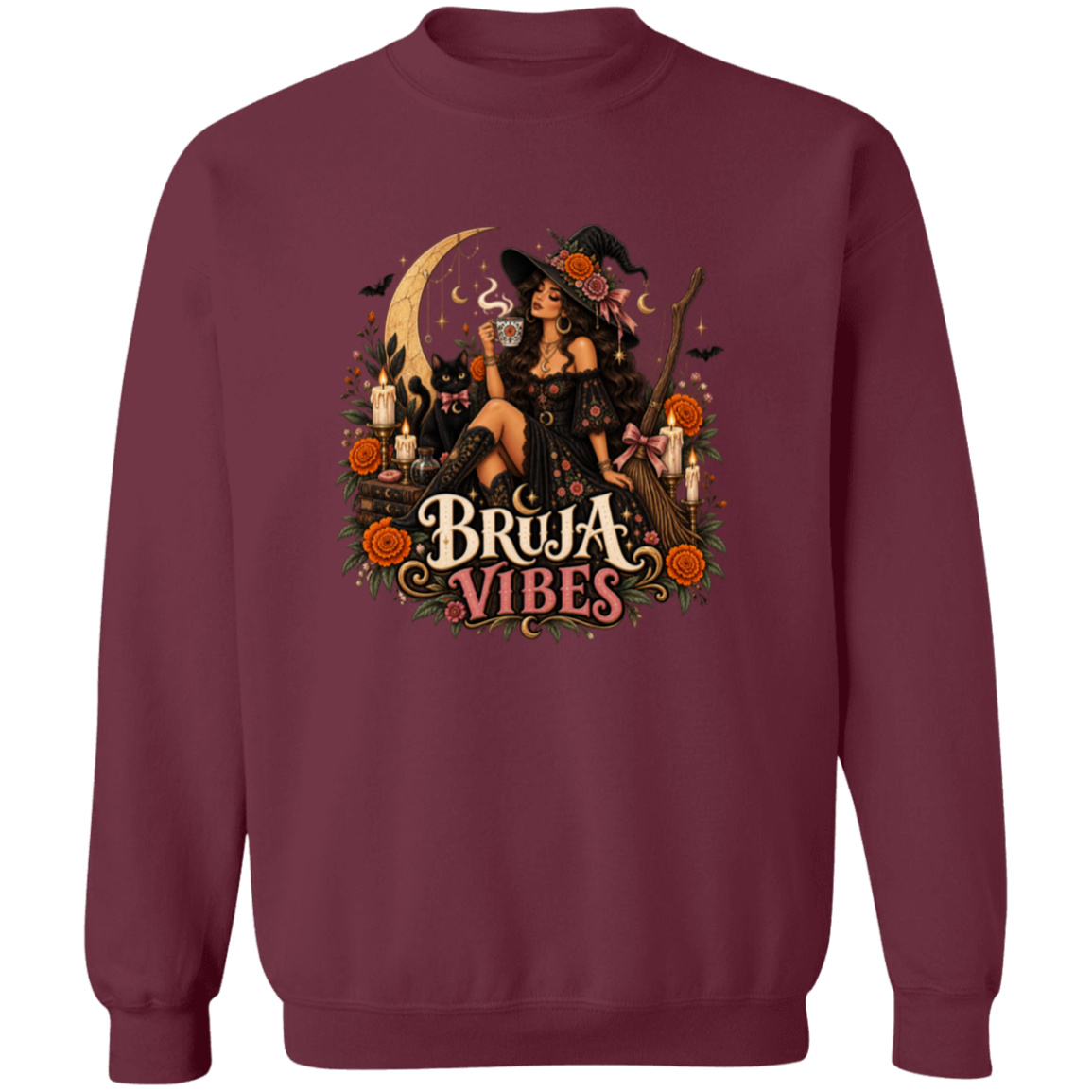 Maroon crewneck sweatshirt with a large graphic print on the front. The graphic features a witch in a black hat sitting on a broomstick next to a black cat, surrounded by orange flowers and the text 'BRUJA VIBES'.