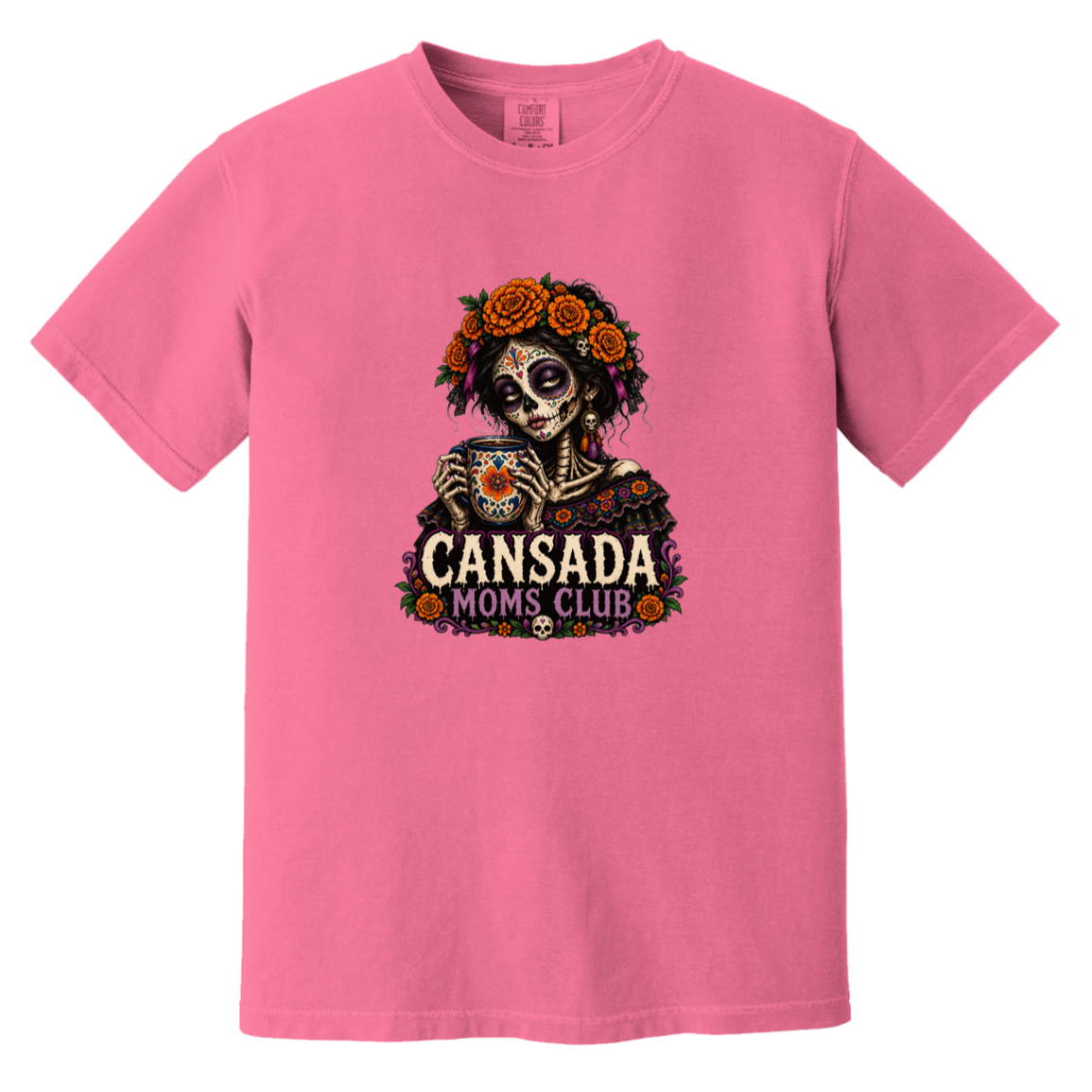 A pink short-sleeve crewneck t-shirt featuring a Day of the Dead sugar skull graphic holding a teacup, with 'CANSADA MOMS CLUB' text and orange roses.
