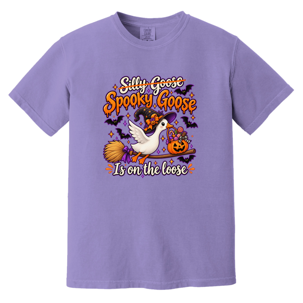 A lavender purple short-sleeve crewneck t-shirt featuring a colorful Halloween graphic on the chest. The graphic shows a white goose on a broomstick next to a jack-o'-lantern, with the text 'Silly Goose Spooky Goose Is on the loose' in orange and white lettering.