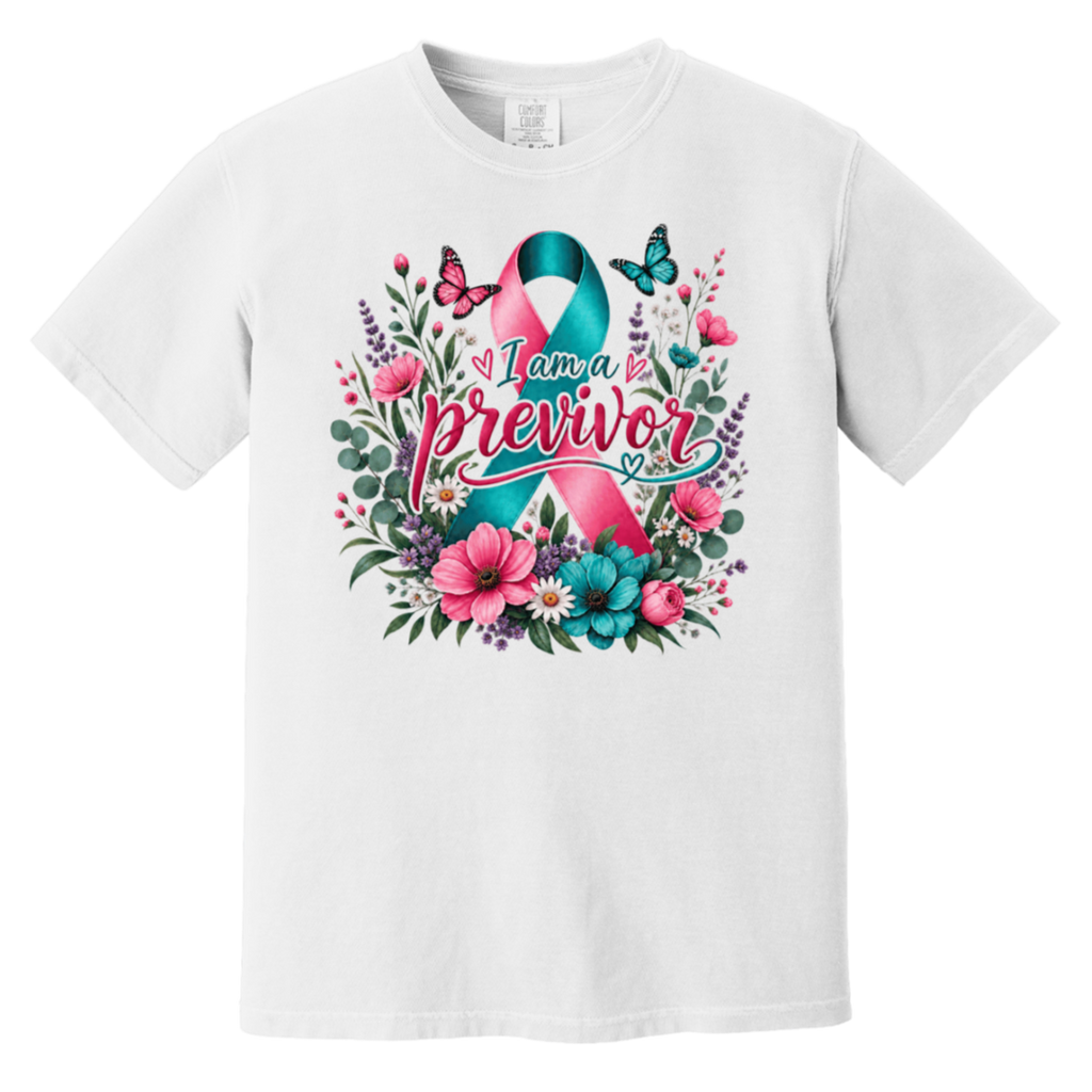 A white short-sleeve crewneck t-shirt featuring a colorful graphic on the front. The graphic displays a pink and teal awareness ribbon surrounded by pink flowers, green leaves, purple blossoms, and butterflies, with the text 'I am a previvor' written across the center.