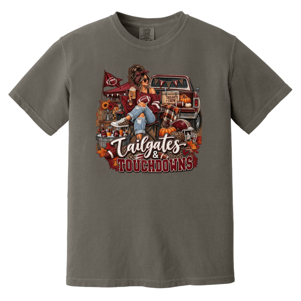 Dark gray graphic T-shirt with a detailed autumn football scene printed on the front, including a truck, pumpkins, sunflowers, and the text 'Tailgates & Touchdowns'.