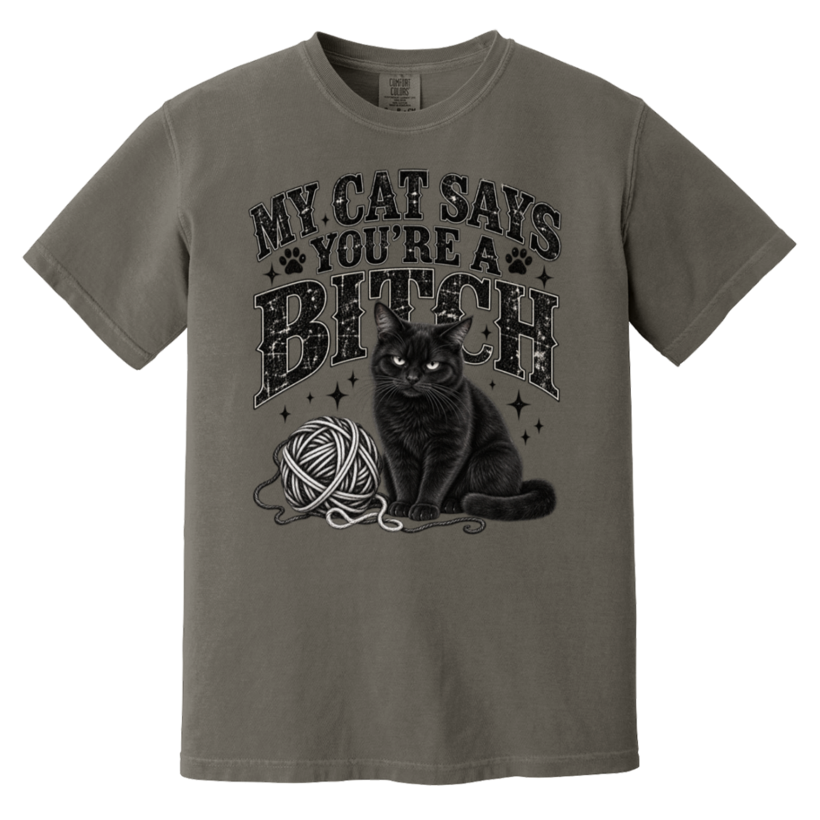 A short-sleeve crewneck t-shirt in a muted grayish-brown color, featuring a black graphic print of a cat sitting next to a ball of yarn with the text 'MY CAT SAYS YOU'RE A BITCH' in a distressed font.