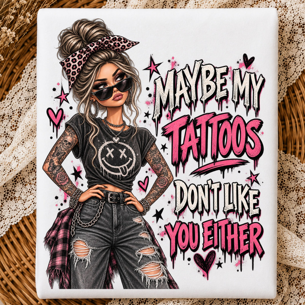 a folded tshirt with a graphic of a woman with two sleeves of tattoos on her arms and a text that says "maybe my tattoos don't like you either" 