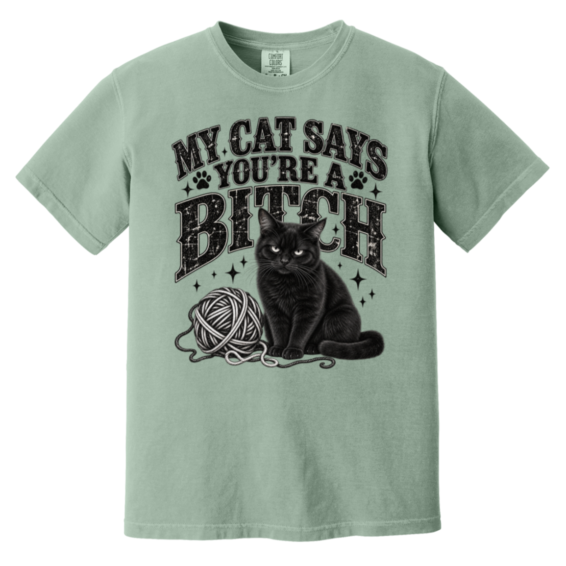 A sage green short-sleeve t-shirt with a graphic print of a black cat sitting next to a ball of yarn under the text 'MY CAT SAYS YOU'RE A BITCH' in a distressed black font.