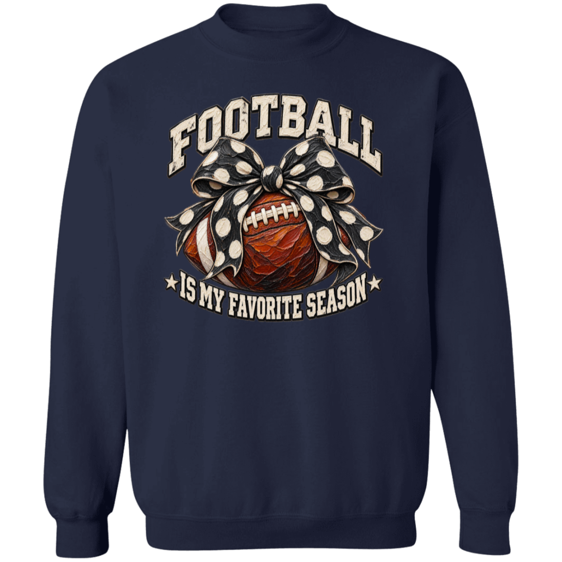 A navy blue crewneck sweatshirt featuring a graphic print on the front with the words 'FOOTBALL IS MY FAVORITE SEASON' in cream lettering, surrounding an illustration of a brown football tied with a black and white polka dot bow.
